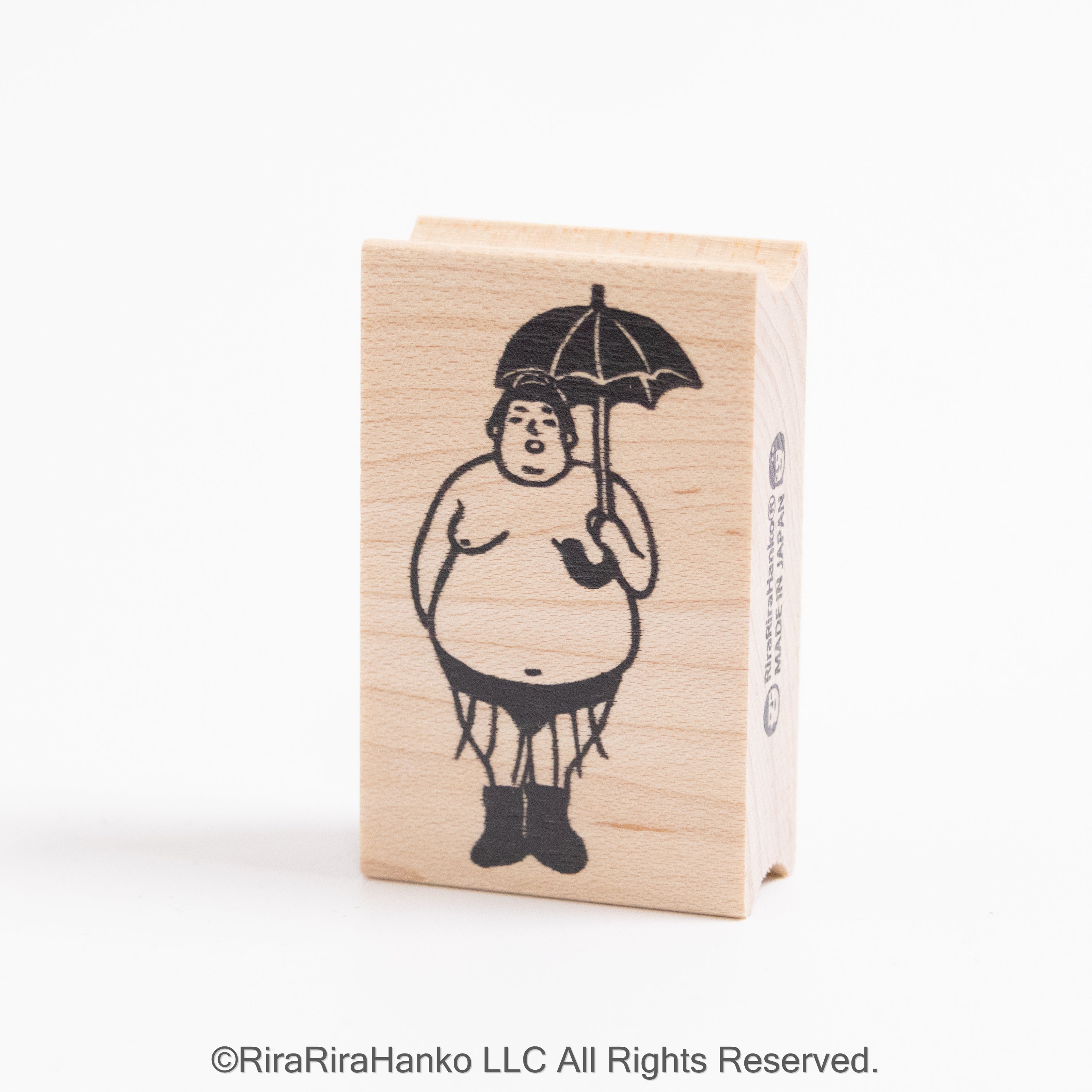 A sumo wrestler holds an umbrella