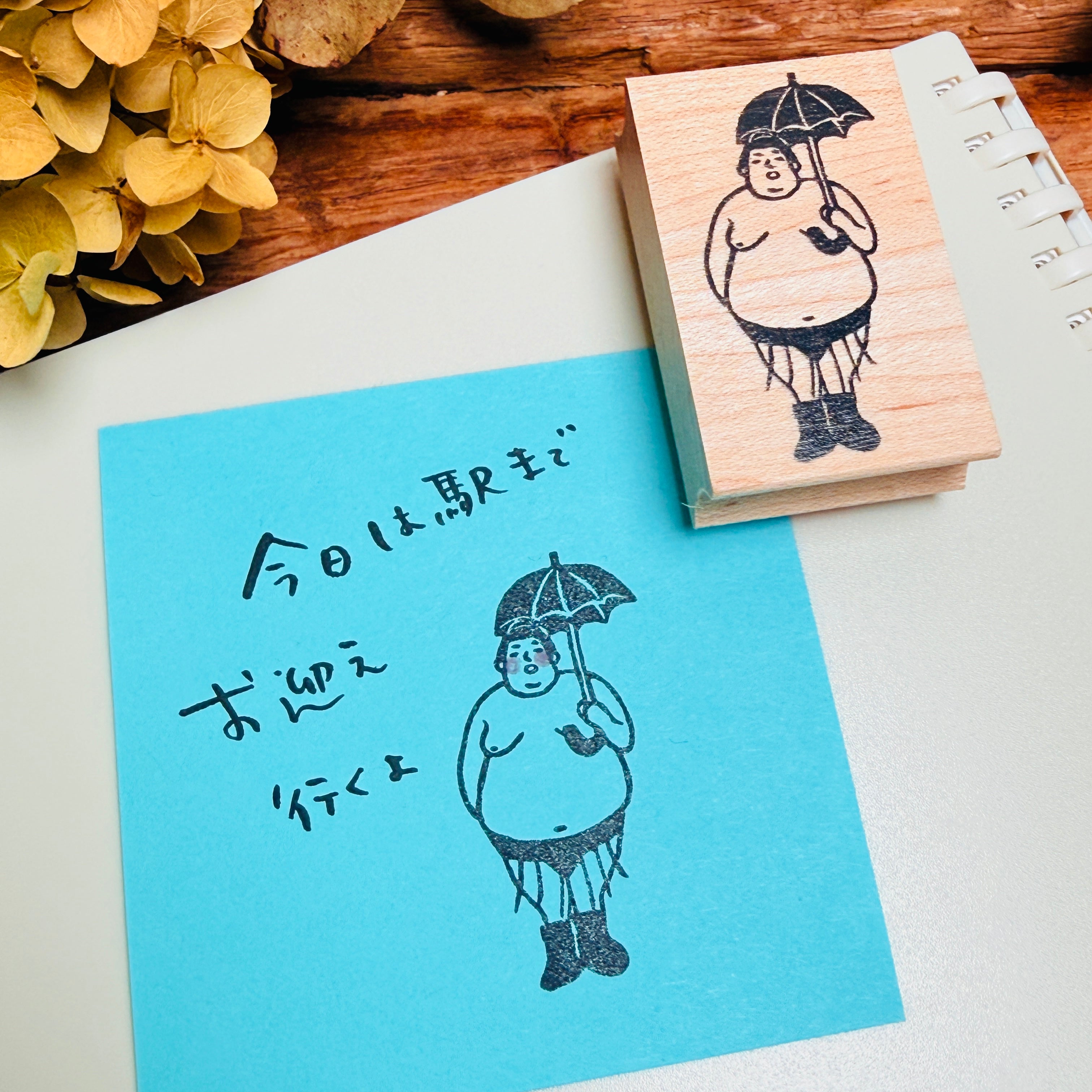 A sumo wrestler holds an umbrella